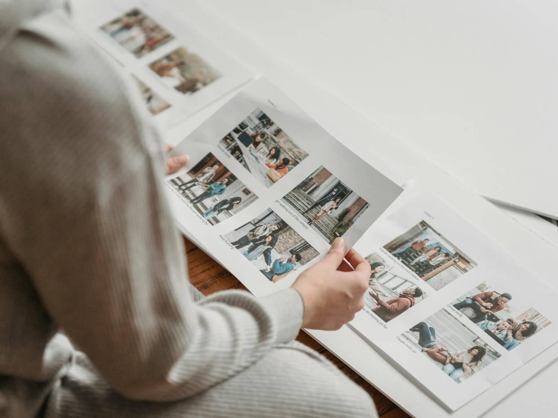 An unrecognizable person looks at printed photos